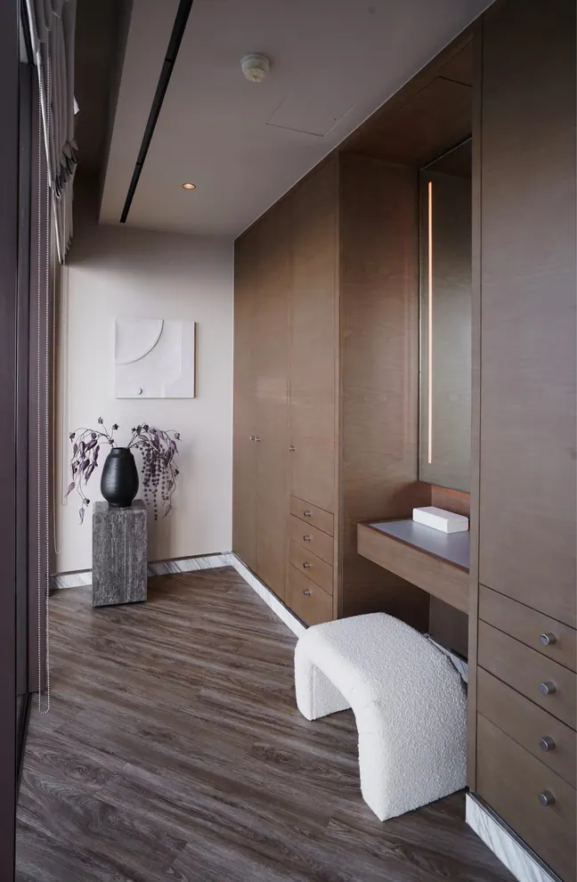 Walnut dressing room with a built-in make-up table and a boucle stool