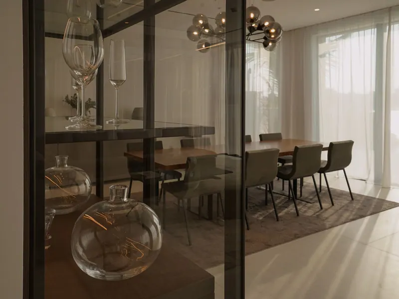 Dining table seen through the glass display cabinet with decanters